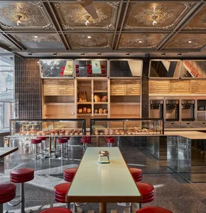 A restaurant dining area with multiple tables, bar stools, and regular chairs, surrounded by inviting atmosphere and comfortable seating options