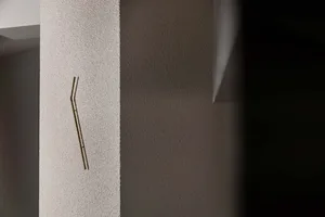 裸露混凝土牆上安裝金屬掛鉤，極簡工業風美學