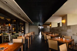 An empty restaurant with wooden tables and chairs, creating a warm and inviting atmosphere