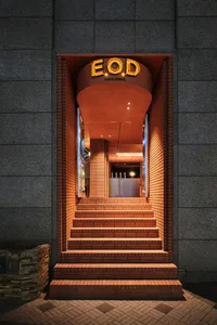 A warm and inviting orange brick building with a large archway entrance and stairs leading to another level