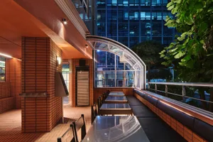 Dining area with glass tables, multiple chairs, and a large window for natural light