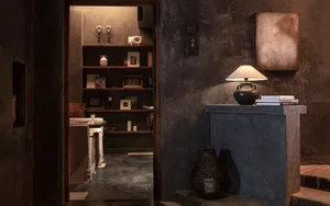 Dark hallway with a doorway, bookshelf, and decorative vase, possibly lacking natural light