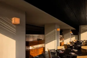 Wooden tables and chairs in a restaurant dining area, set up for serving food with a focus on comfort and ambiance