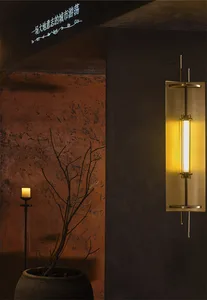 Cozy living space with a brick wall, a tree branch with sconces, and two potted plants