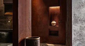 Warm and inviting interior space with a brown wall, a vase, a bowl, and natural materials like wood and stone