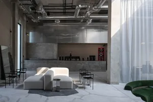 Bright and inviting open concept living area with a white couch, chairs, and scattered cups, featuring clean lines and minimalistic design elements