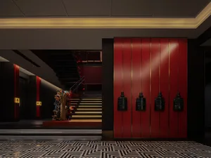 A busy public space with red walls, black doors, and people scattered throughout the area