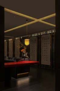 Dimly lit Asian restaurant interior with a red countertop, yellow lamp, and oriental writings on the walls