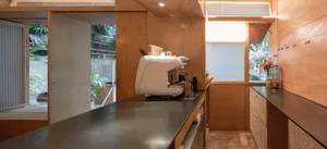 A clean and organized kitchen with a white coffee maker on the counter, surrounded by cups and bottles