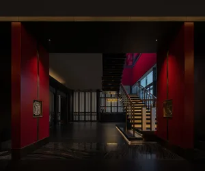 Elegant staircase with wooden steps and black railing, illuminated by sunlight in a modern and stylish interior
