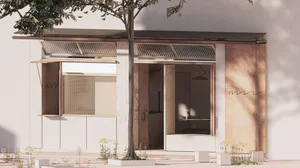 A modern residential entrance with a wooden door and a tree in front, surrounded by neutral tones and natural light