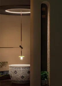 Modern bathroom with a patterned sink, a hanging lamp, and two potted plants, creating a stylish and functional space