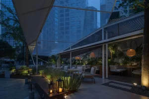 A spacious interior space with multiple seating areas, chairs, and a dining table, designed for relaxation and socializing