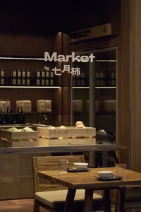 Cozy Asian restaurant with wooden floors and walls, featuring a dining table with bowls and cups, and a counter in the background