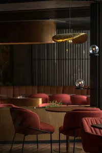 A warm and inviting restaurant dining area with multiple chairs and tables arranged throughout, creating a comfortable atmosphere for guests