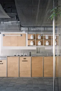 Industrial kitchen with wooden cabinets, metal countertops, and bottles placed on the countertops in various positions
