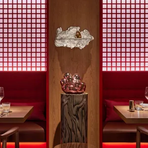 A cozy dining area with two red chairs and a dining table, featuring wine glasses and a warm atmosphere