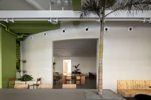 A cozy restaurant with multiple chairs and tables, potted plants, and a warm atmosphere