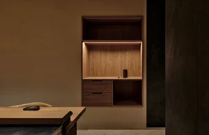 A dimly lit room with a wooden cabinet, a drawer, and a shelf, accompanied by two bowls on the countertop