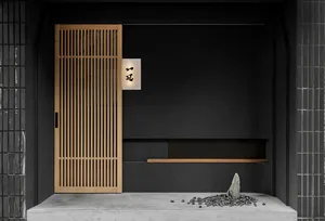 A dark room with a black door featuring wooden panels, two benches, and a rock, creating a unique interior design
