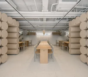 Empty restaurant with a large wooden dining table and comfortable seating area, clean and well-organized