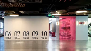 乾淨整潔的辦公空間，擁有大型白色牆面以黑色數字展示，周圍環繞座椅與極簡氛圍