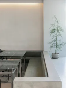 Empty room with a white wall and a green couch, two chairs, and a calm atmosphere
