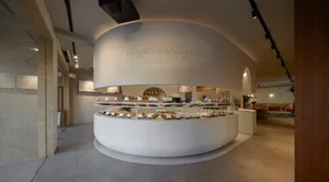 麵包店內部設有大型展示櫃，滿載糕點與麵包，營造溫馨誘人氛圍