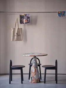 A modern dining space with a unique table and two black chairs, surrounded by a stylish and contemporary atmosphere