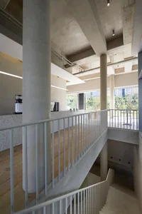 Open modern space with metal railings on two sets of stairs, clean lines, and simple design elements, well lit by natural light