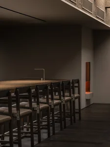 Empty restaurant with wooden floors and walls, featuring comfortable seating arrangements and inviting atmosphere