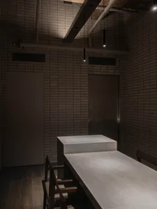Cozy kitchen dining space with brick walls, two tables, and dim lighting