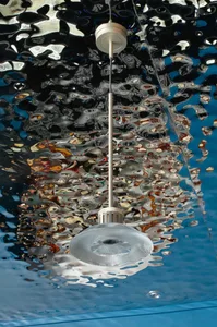 Underwater hotel lobby with a large metal chandelier reflected in the water, surrounded by a captivating atmosphere