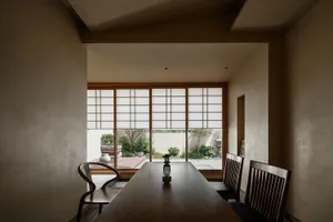 A cozy dining area with a wooden table and chairs, natural light from a window, and a warm atmosphere