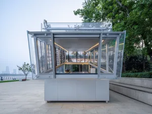 Bright and airy office space with a modern design, featuring a large glass wall, concrete walls, and multiple windows