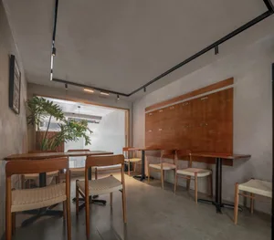 Modern restaurant interior with wooden tables, metal accents, and various seating options
