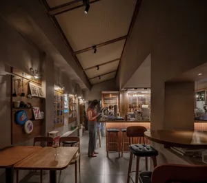 充滿活力的餐廳場景，現代設計、木質元素與當代家具，牆上掛有藝術品，並融合環境光與任務照明