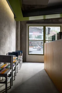 Empty restaurant with chairs near a large window, allowing natural light to enter and creating a calm atmosphere