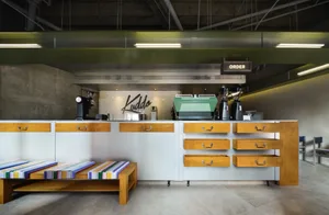 Industrial kitchen with a counter featuring various appliances, clean and organized with a focus on functionality and efficiency