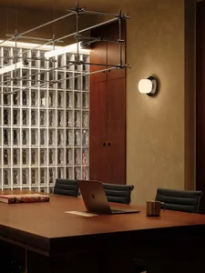 Modern office space with a wooden desk, glass wall, and natural light