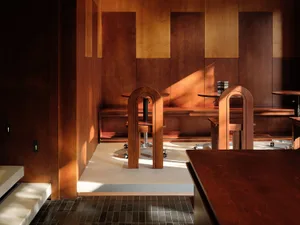 Warm and inviting restaurant interior with wooden tables and chairs, featuring a cozy ambiance