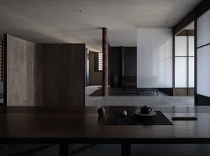 Empty modern living room with wooden floors and walls, featuring a dining table and two chairs