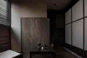 Cozy living space with a wooden table, bench, and vases, surrounded by warm and inviting atmosphere