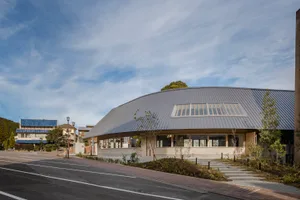 Modern building with a curved roof, brick and metal exterior, and large windows providing natural light