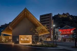 A modern house with a triangular roof and wooden exterior, featuring multiple windows and a cozy atmosphere