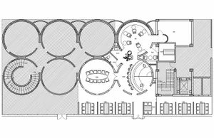 A modern floor plan featuring a large circular area surrounded by chairs, with clean lines and minimalistic design elements, well-lit with possible windows or artificial light sources