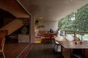 A cozy dining area with a table, chairs, and potted plants, creating a warm and inviting atmosphere