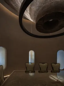 Warm and inviting dining space with a round table, stone walls, and natural light from windows