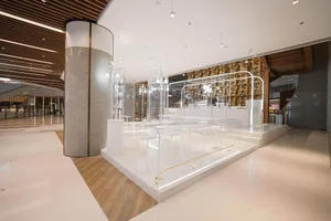 A modern interior design showroom with a glass bar, white countertop, and comfortable seating arrangement