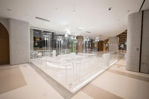 明亮潔淨的購物中心，擁有大型玻璃牆展示商品陳列，以及多張桌椅，營造溫馨邀約氛圍